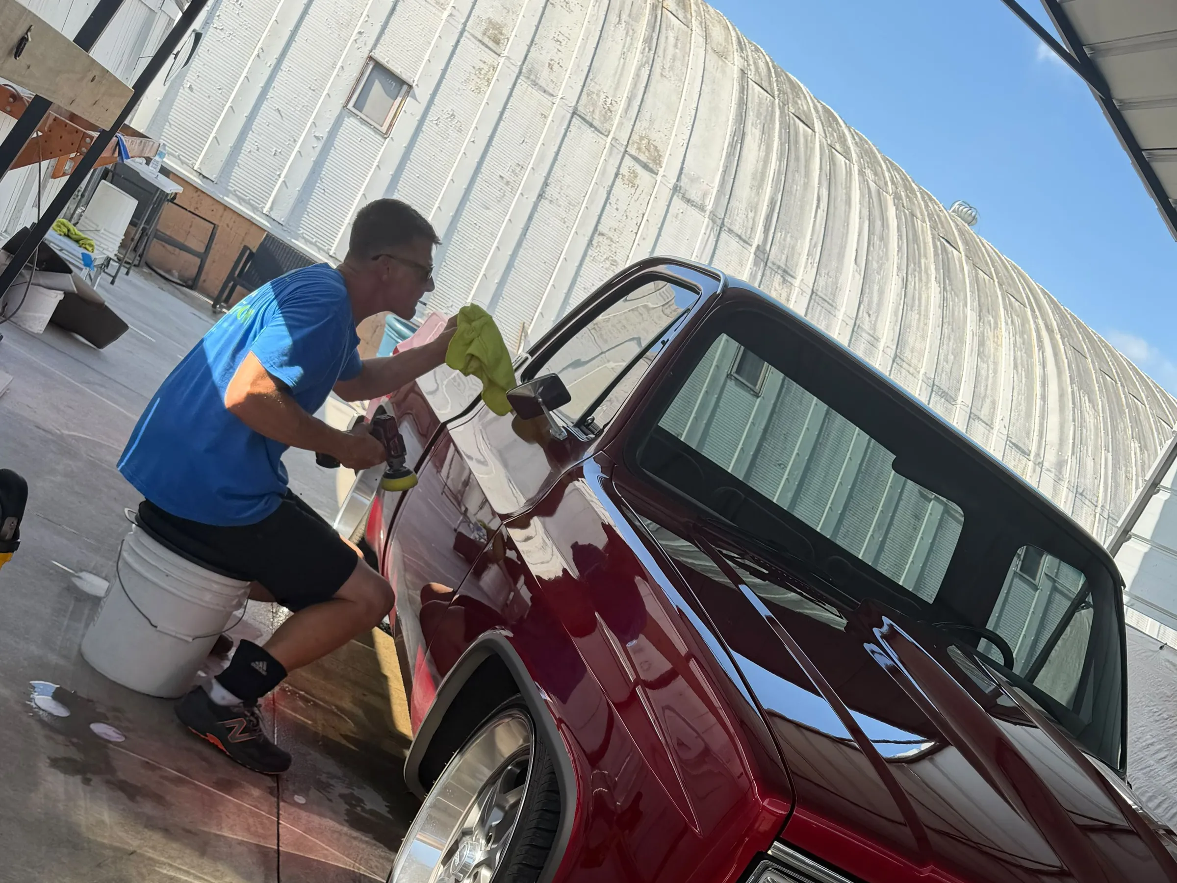 Punta Gorda Detail detailer machine polishing the door of a red classic Chevy pickup.